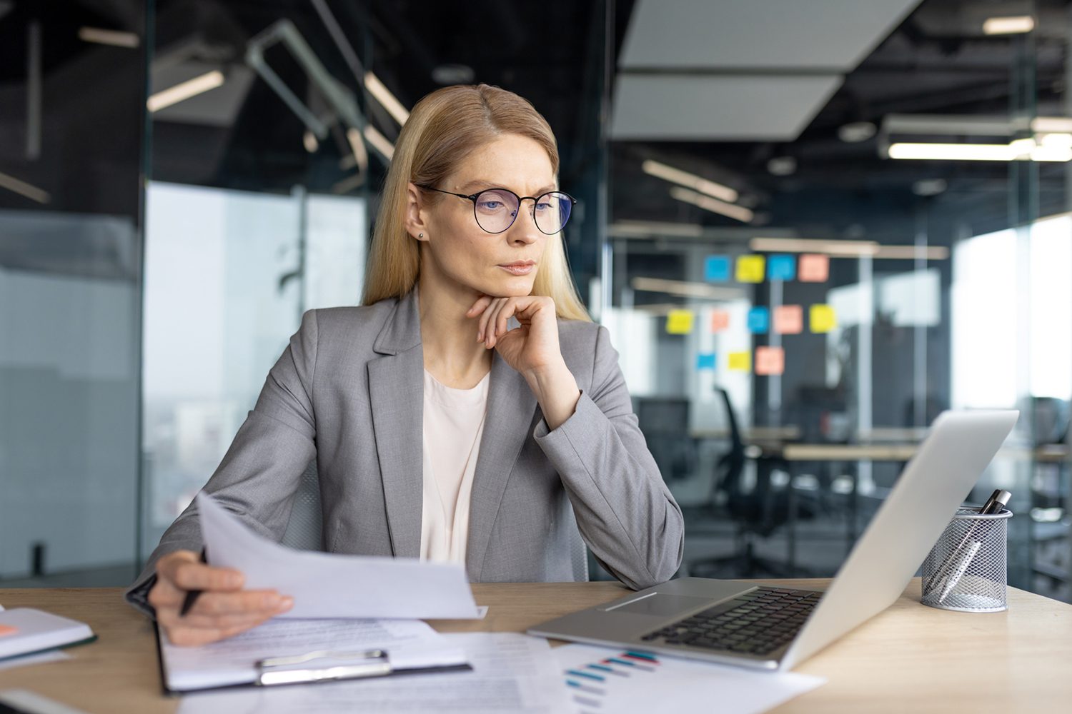 Businesswoman analyzing documents at desk